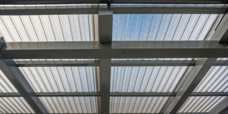 Pergola-style carport structure with translucent UV fabric installed for shaded vehicle parking